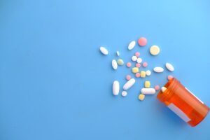 Comprimidos e cápsulas saindo de um frasco de medicamento, ilustrando armazenamento e validade