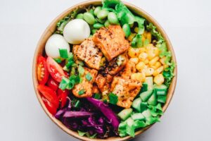 Tigela com salada, legumes e proteína, representando alimentação equilibrada